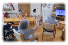 木製テーブルと椅子が配置された共用スペースで、入居者が過ごしている様子